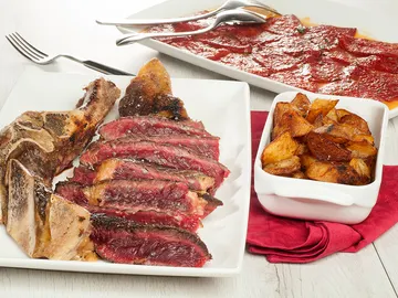 Chuleta en casa, piquillos y patatas al ajo Chuleta en casa, piquillos y patatas al ajo