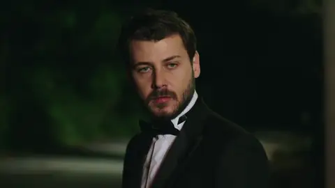 Ahmet se ofrece a ayudar a Zeynep y su familia bajo la atenta mirada de Onur Ahmet se ofrece a ayudar a Zeynep y su familia bajo la atenta mirada de Onur